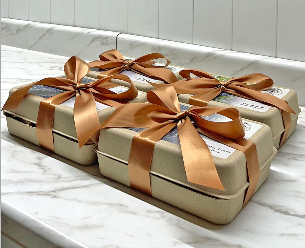 Four gift boxes tied with brown ribbons on a marble surface