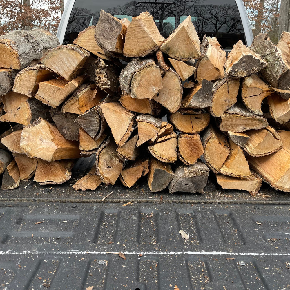 Stack of firewood in the back of a pickup truck